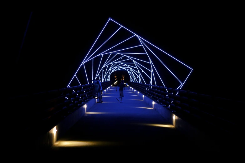 blue lights shine in the dark above a walkway