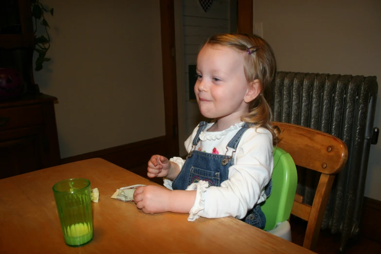 a child with white hair sitting at a table