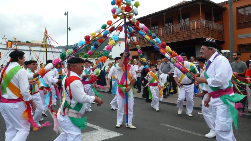 colorfully dressed men carry flags during a parade