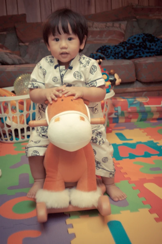 a small child wearing a pajamas is sitting on a large plush toy