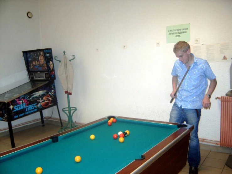 two men standing around a green pool table