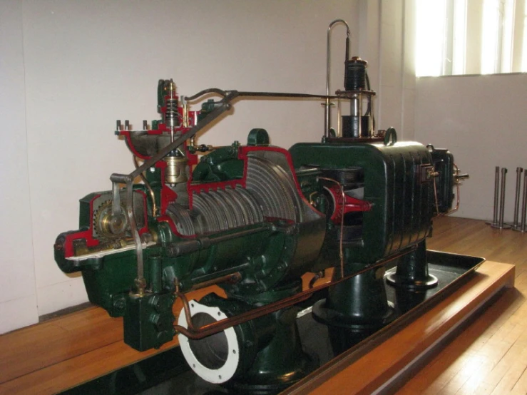 a black train engine on display on a wood table