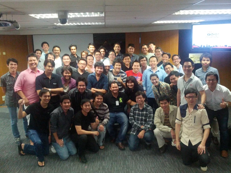 people posing for a group pograph together in an office