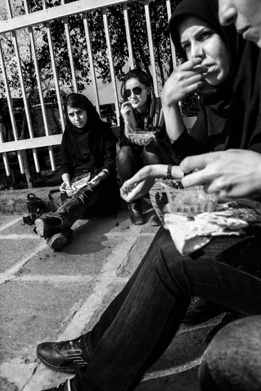 a group of people sitting on steps eating food