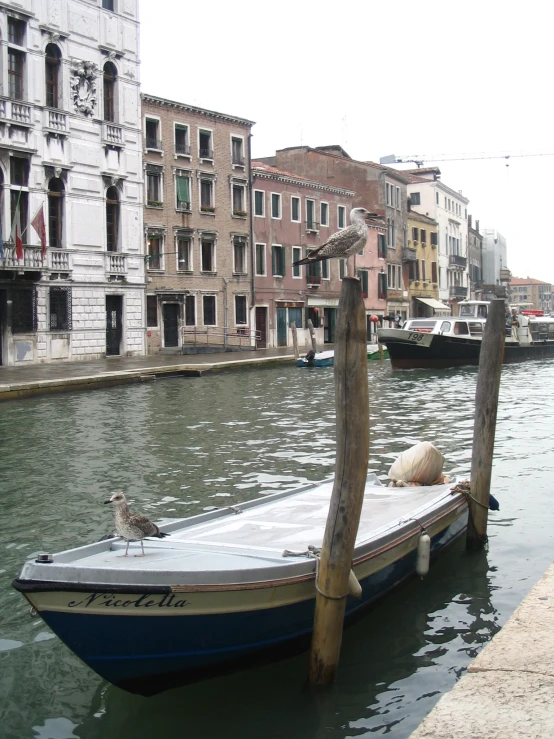 small boat at dock with city buildings in the background