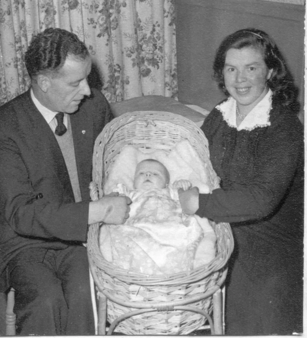 an old po of two people holding up a baby