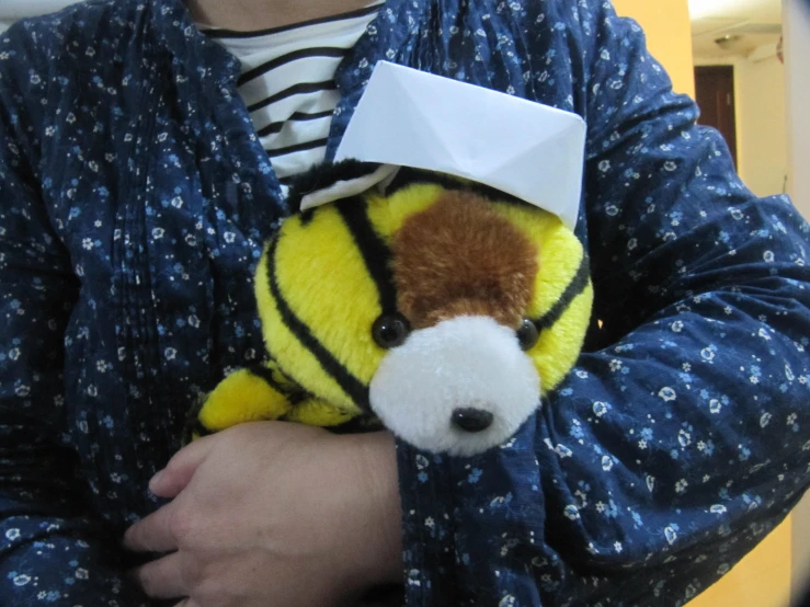 a man holding a yellow stuffed animal on his chest