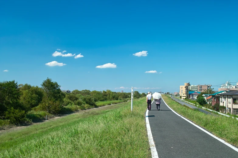 two people walking down a paved path in the city