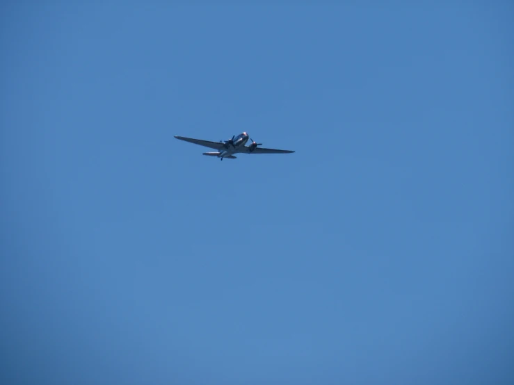 an airplane in flight through a clear blue sky