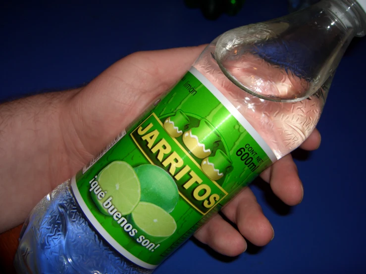 a person holding a jar of margarita lime water