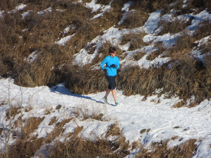 a young man is running uphill on snow covered mountain