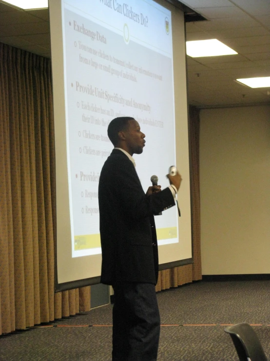 a man wearing a suit holding a microphone standing up