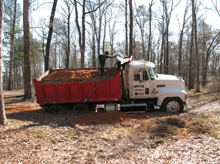 a white and red truck pulling a white trailer behind it