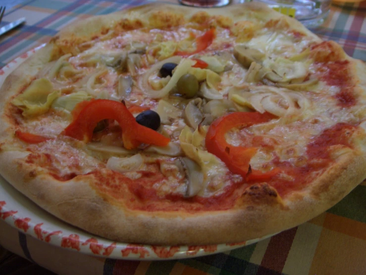 an italian pizza with olives, peppers and garlic