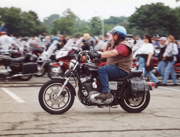 a motorcyclist rides through the crowd on a street