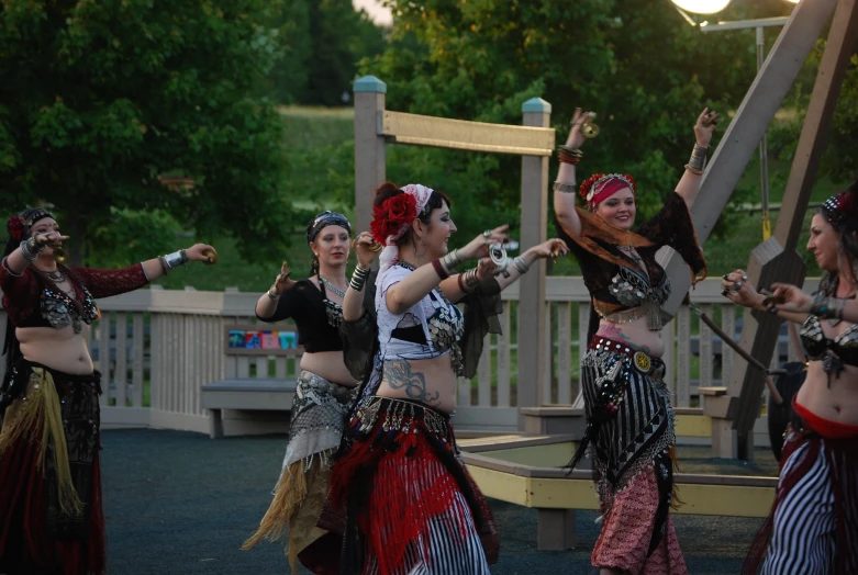 girls in costume dancing outside and some trees