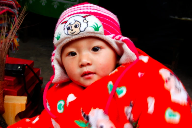 a small child wears a red and white outfit