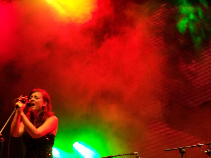 a woman on stage holding a microphone in her hand