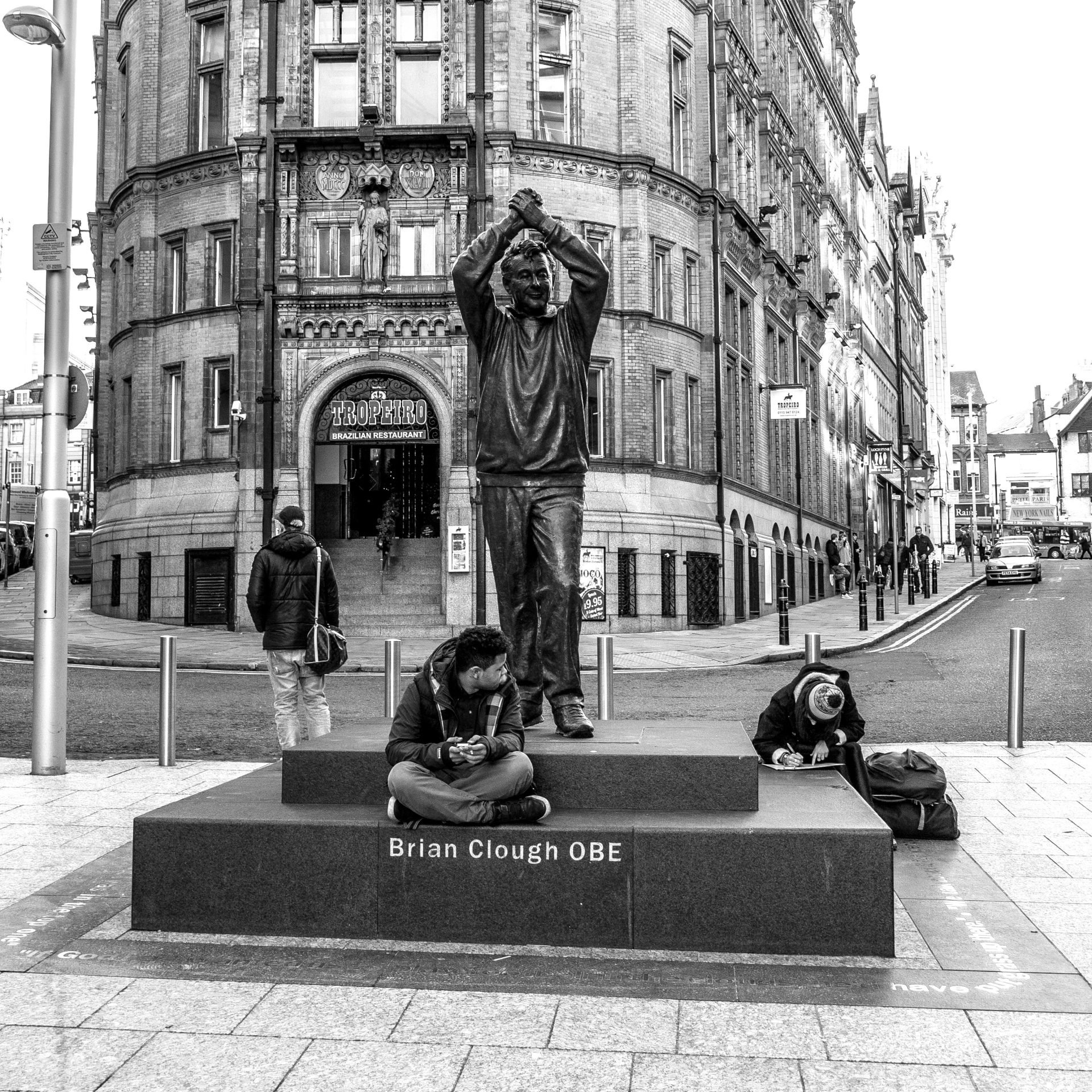 a couple of people sitting next to a monument