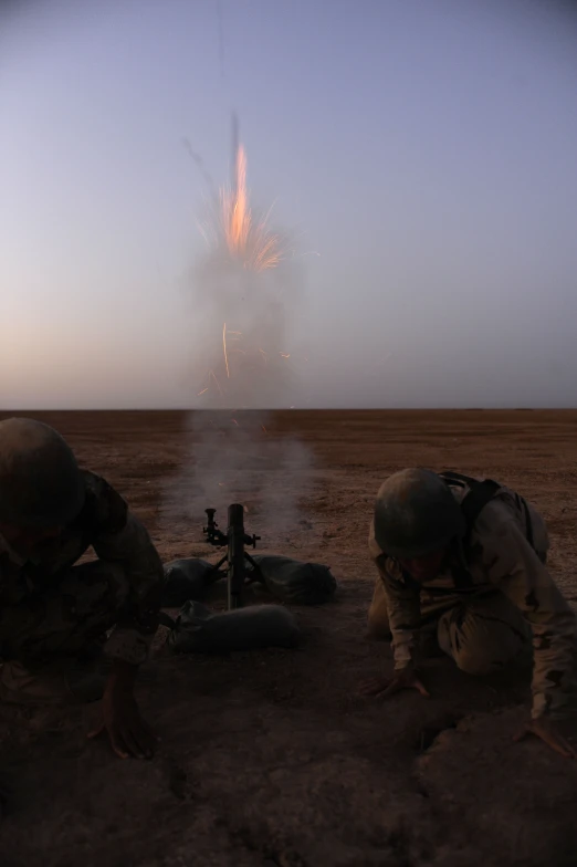 two soldiers kneeling next to each other next to a firework