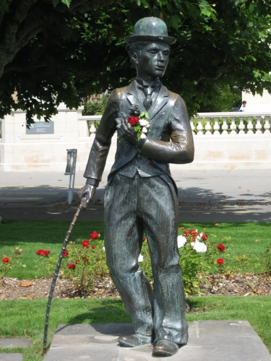 a statue in a suit holds a rose