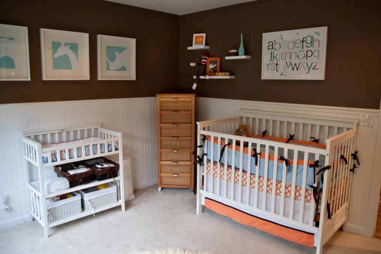 a baby's room decorated with brown and orange accents