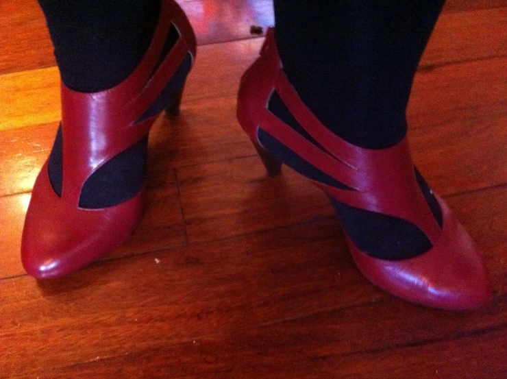 a woman's feet wearing red, purple and black high heels