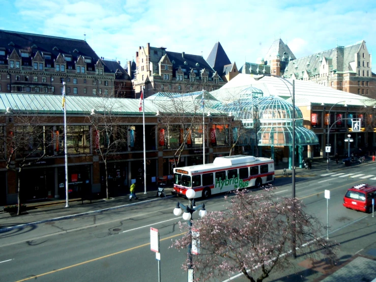 city street with bus driving down the street near a shopping center