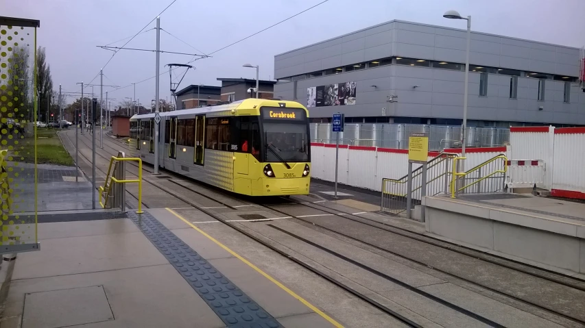 a yellow and grey trolley going down tracks