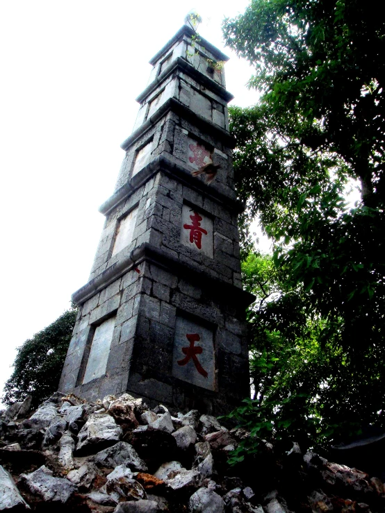 a large stone structure sitting on top of a hill next to some trees