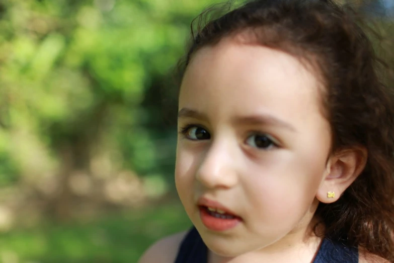 a young child with curly hair in a park