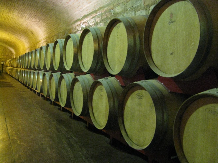 barrels stacked in a wine cellar at the end of a tunnel