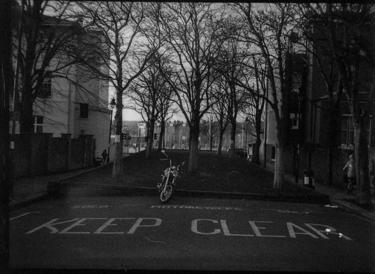 a black and white po of a bike parked at the end of a quiet street