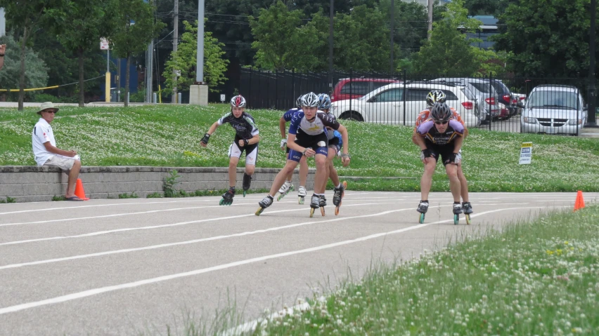 several people riding roller blades down a road