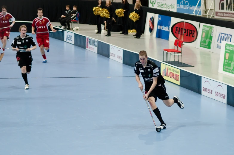 men in uniforms play soccer on an indoor court