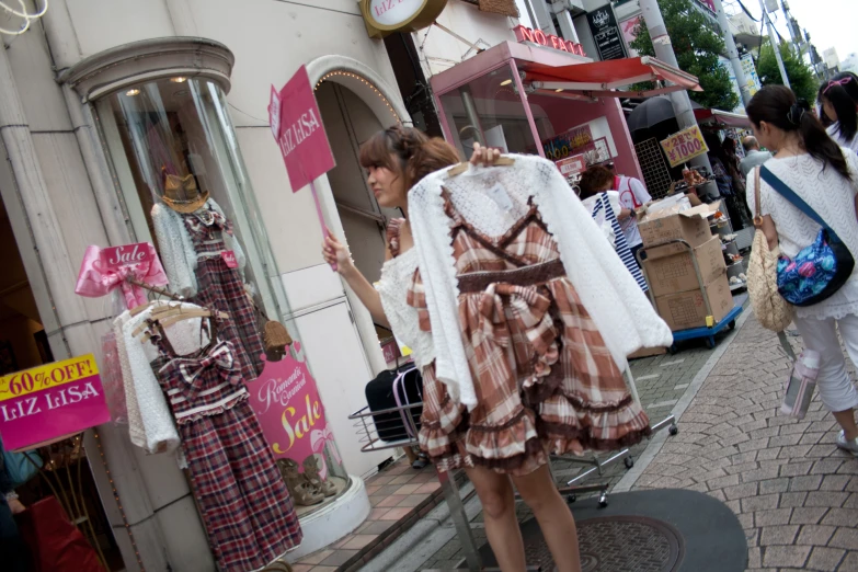 there is a woman standing outside a clothing store