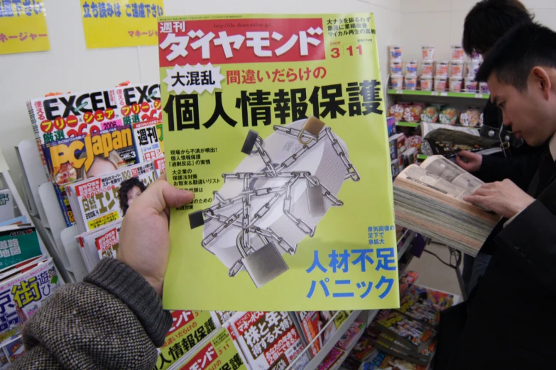 an asian man reads the magazine on the street