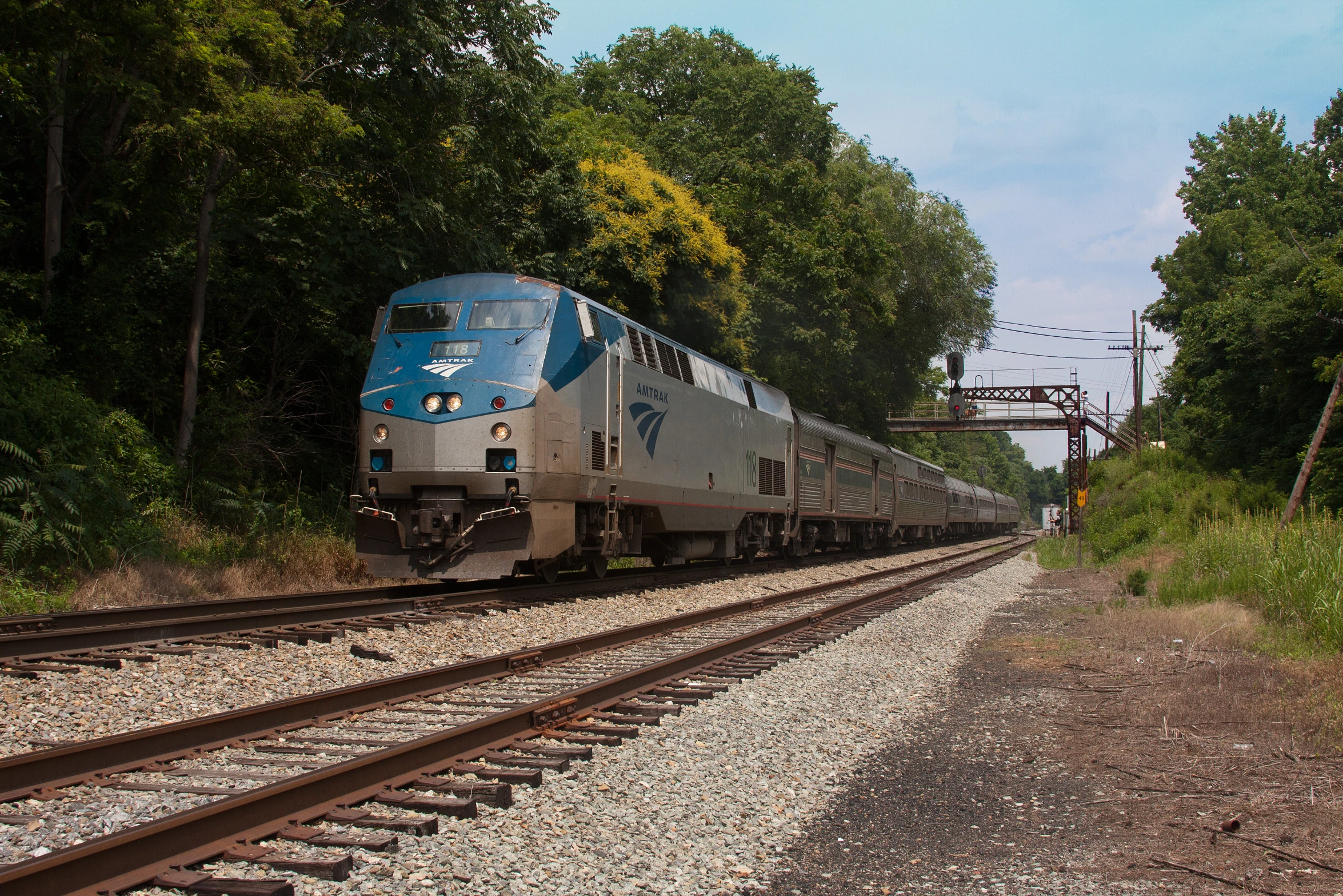 blue and gray train pulling out of a station