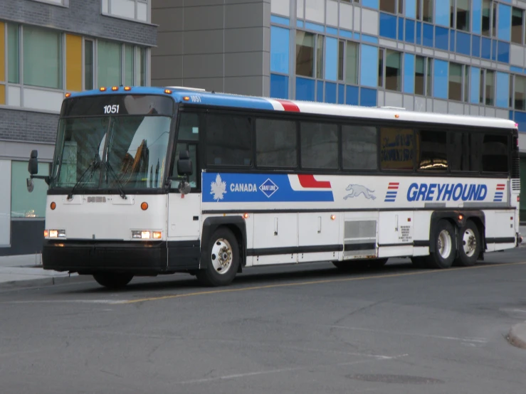 a bus driving down the road near tall buildings