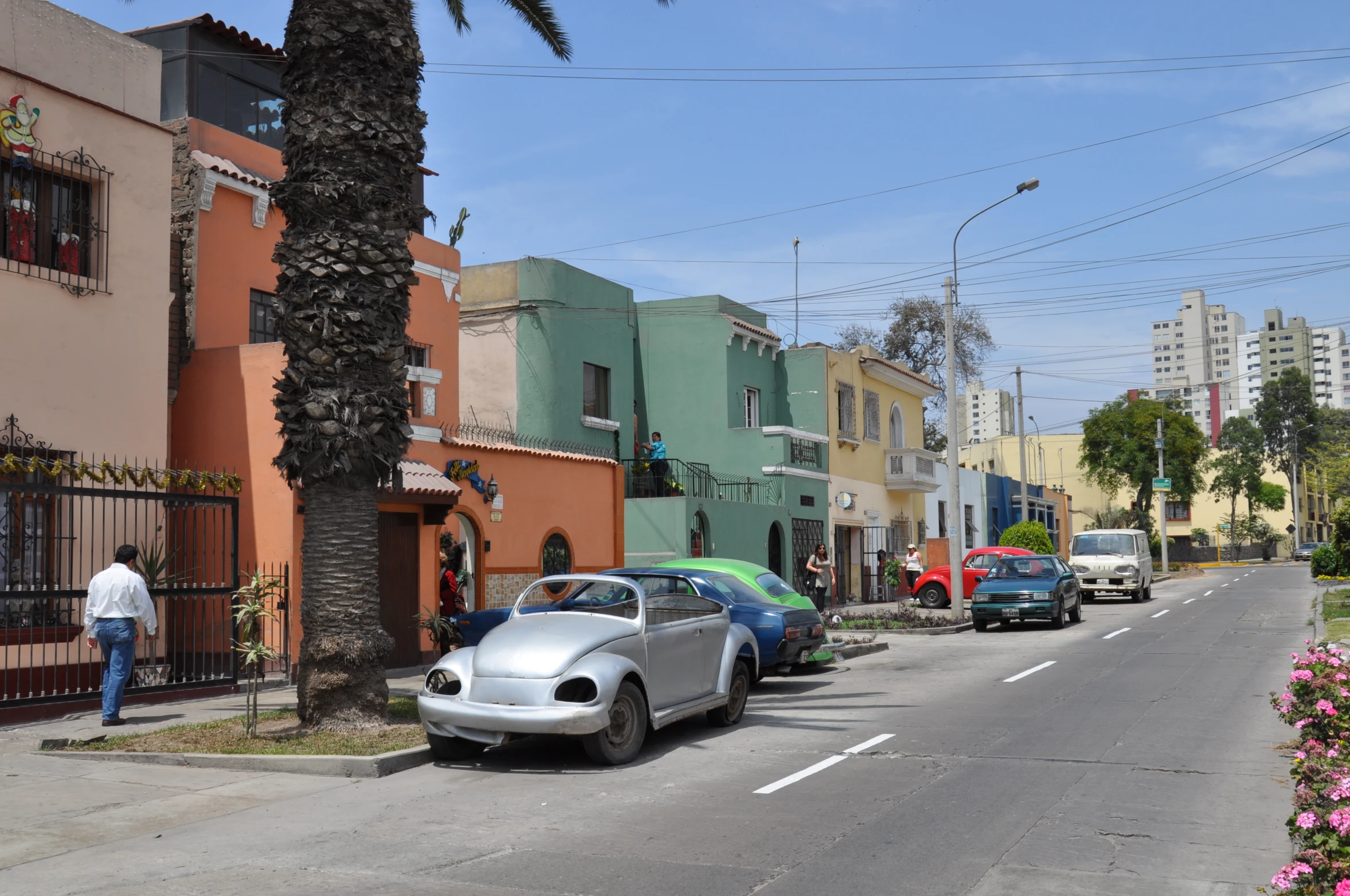 a row of parked cars line the street with people