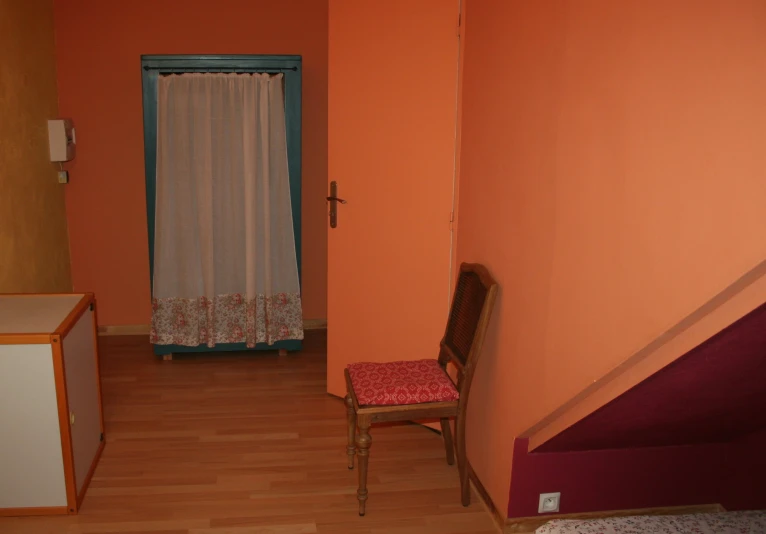 an empty room has a chair near a doorway