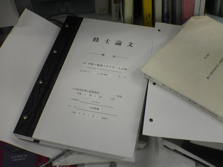 various books and binders sit on top of a table