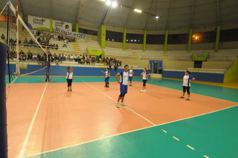 a group of s playing volleyball in a court