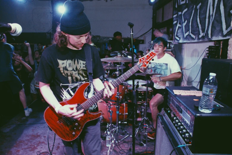 a man playing an electric guitar in front of a microphone