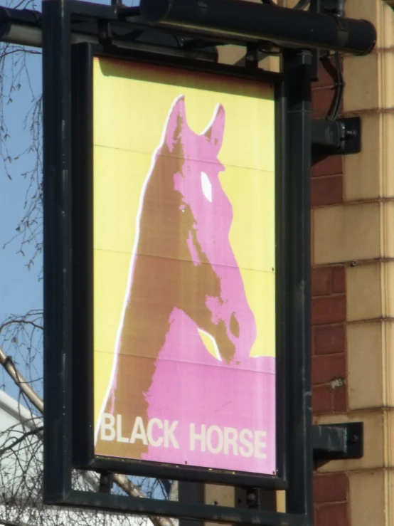 there is a pink and yellow horse sign hanging on the wall