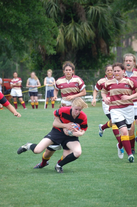 several girls are running with a football on the field