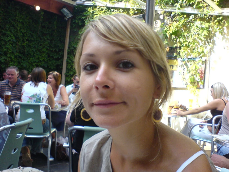 a woman wearing some nice earrings and standing in front of others