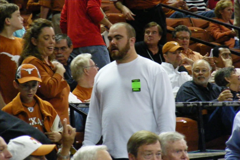 man in white shirt walking in front of spectators