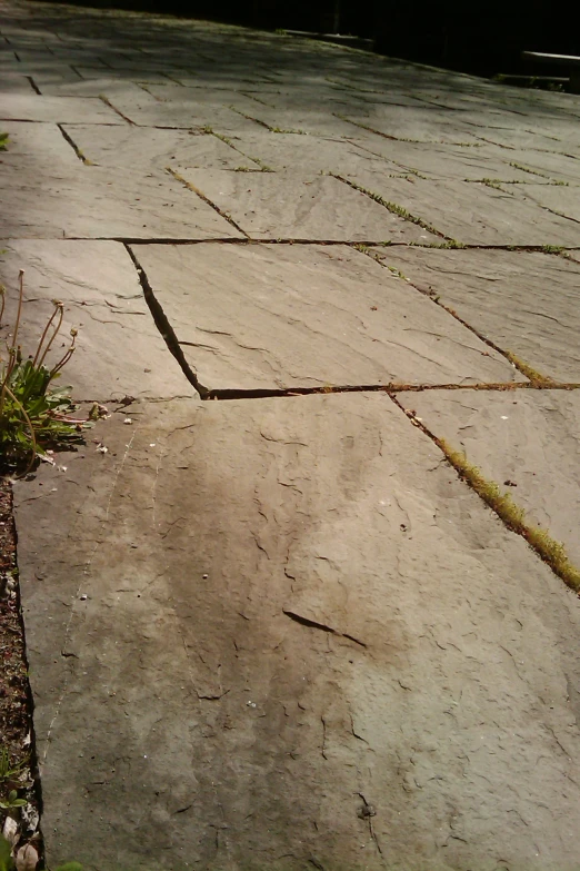 a street with an old cement surface that is falling apart