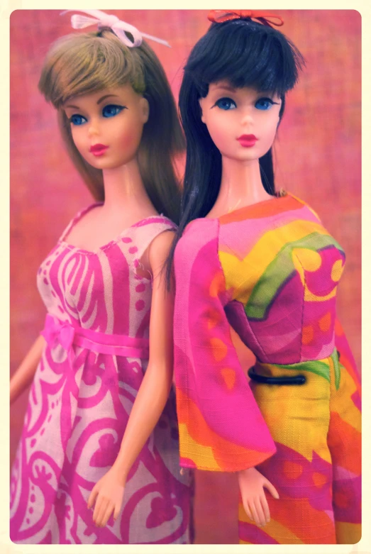 two doll in brightly colored clothes, one is barbie with big blue eyes